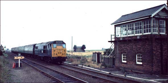A Birmingham train from Norwich at Turves next to the Three Horse Shoes signal box  in BR days