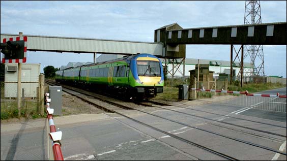 At the road crossing at Kings Dyke to the to the frozen chip factory is a Central Trains class 170 to Peterborough in 2003.