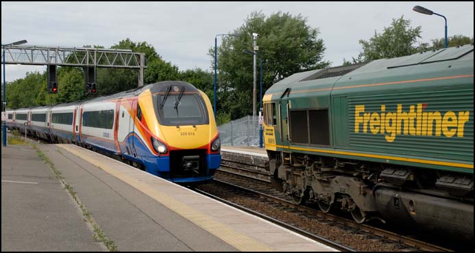 East Midland Trains 222 015 from Corby comes into Kettering while Freightliner Class 66615 with a freight has had to wait 