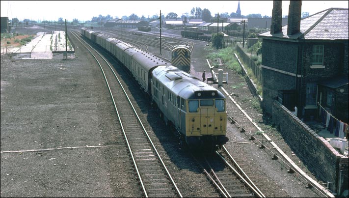 A class 31 on a long parcels train past the site of the closed east station