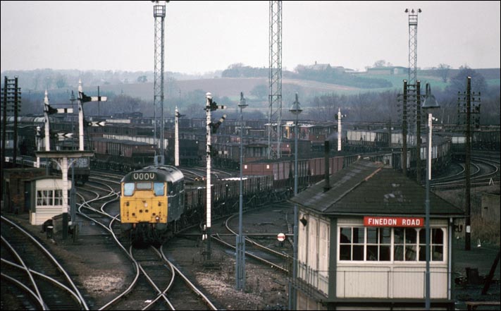 class 31 comes of the goods yard at Wellingborough past Finedon Road signal box